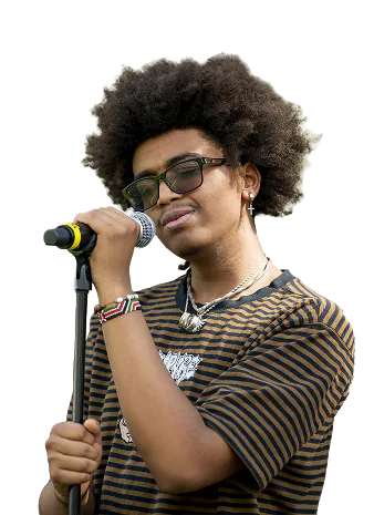 Young man with afro hairstyle wearing glasses, a striped shirt, and jewelry singing or speaking into a microphone.
